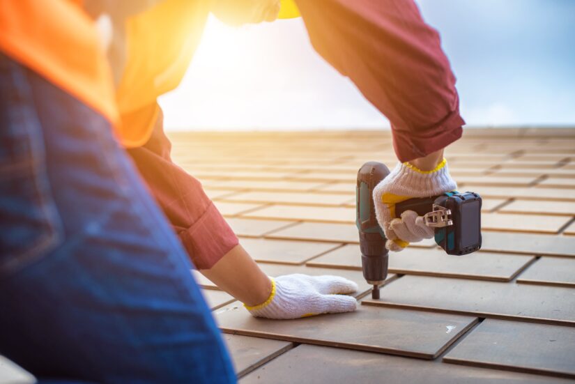 Photo of a Worker Installing Roof Tiles