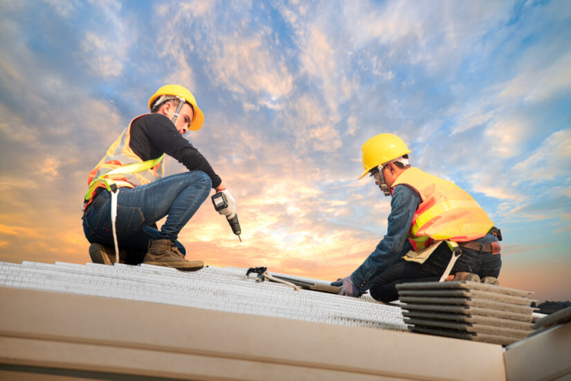 Photo of two men working on roof