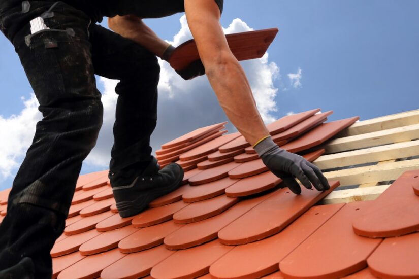 Roofing Worker Laying Down Roof Tiles