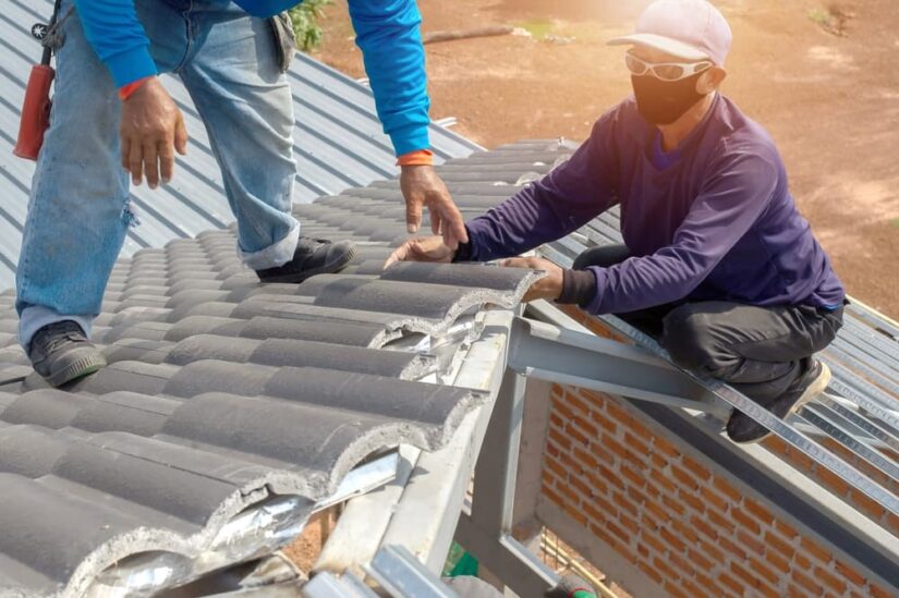 Two Construction Workers Working On The Roof